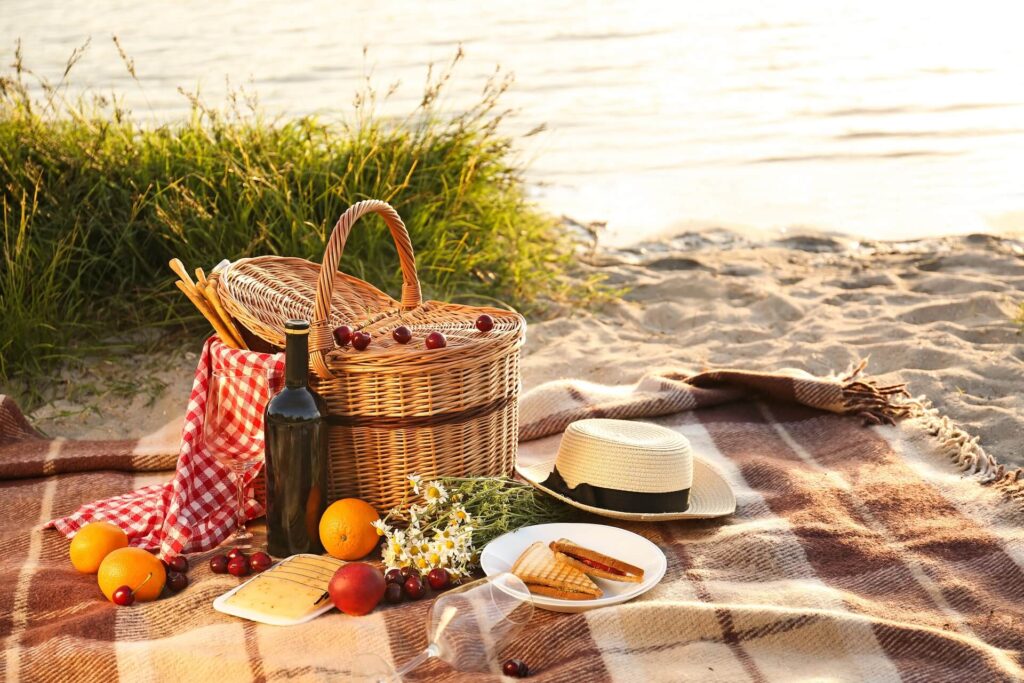 Кошница за пикник за романтична вечеря на плажа край реката.