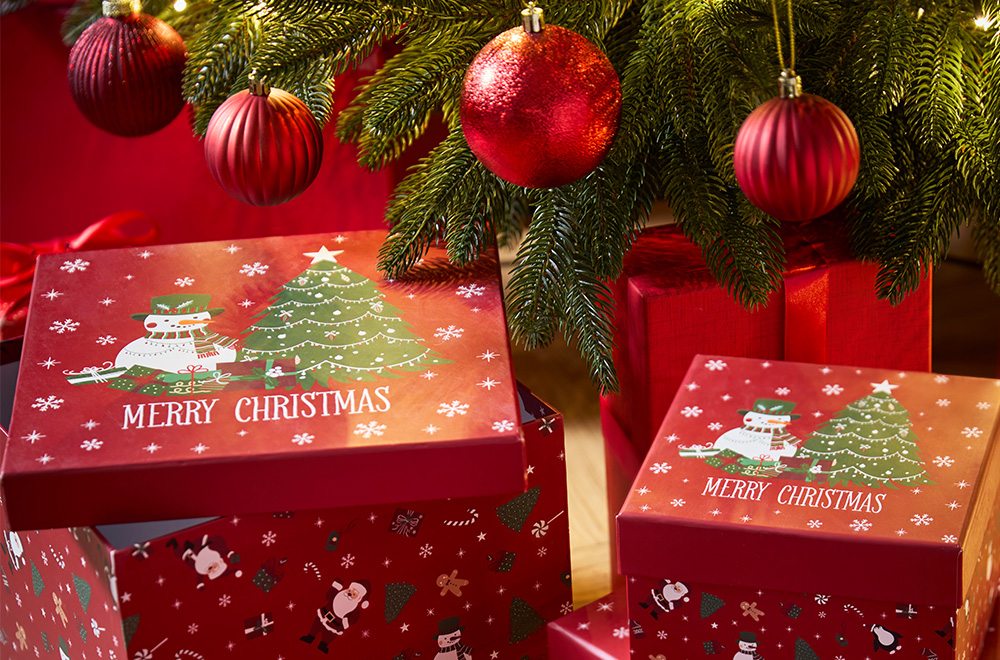 Подаръчни кутии с коледни мотиви до елхата.